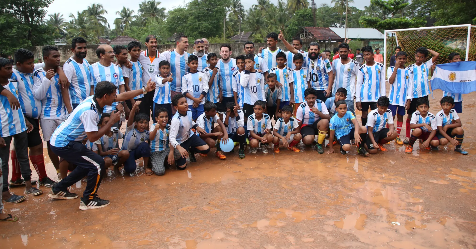 Academy players in kit with their coaches on the pitch